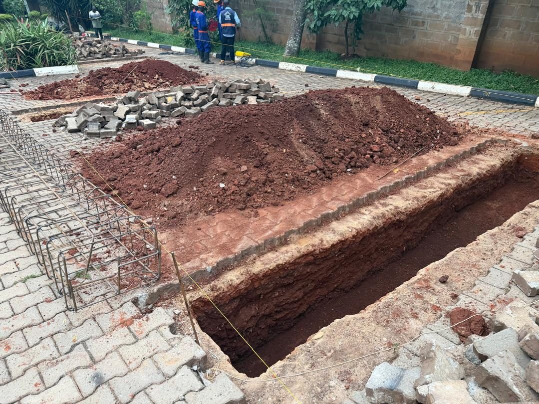 Foundation trench excavated, with a reinforcement cage laid out beside it